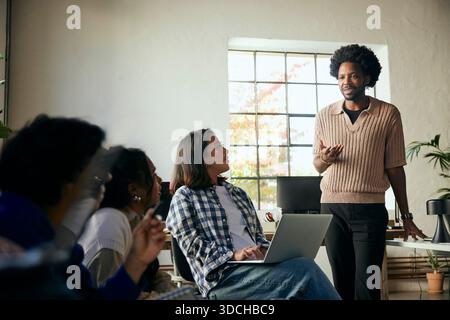 Male business expert discussing ideas with coworkers in startup office Stock Photo