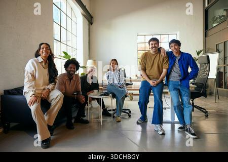 Group of smiling multiracial male and female tech experts looking at camera while posing in new office Stock Photo
