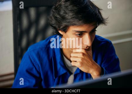 High angle view of focused young businessman working in tech office Stock Photo