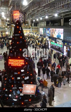 London, UK. 22nd Dec, 2025. At Waterloo Station the concourse is packed as commuters and tourists wait for their trains during rush hour three days before Christmas. A reduced service will be running on Christmas Eve and over the holiday period. The Christmas tree has been sponsored by Netflix to promote the final season of Stranger Things. Credit: Anna Watson/Alamy Live News Stock Photo