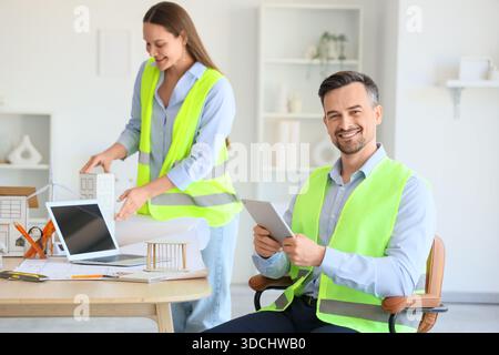 Young architects working with 3D house model at table in office Stock Photo