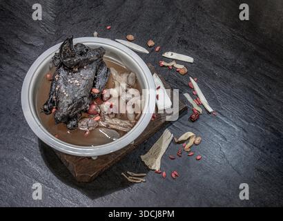 A revered staple in Chinese and Asian culinary traditions, the nourishing health stew pictured is widely celebrated as "Black Chicken Soup" also known Stock Photo