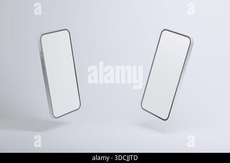 Two modern smartphones with blank white screens floating against a light background, minimalistic mockup concept for mobile apps, technology, digital Stock Photo
