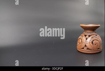 Decorative ceramic candle holder with carved ornament isolated on dark background Stock Photo