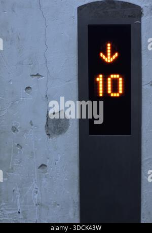 Elevator floor indicator showing number 10 with downward arrow. Stock Photo