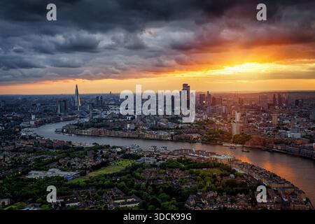 Dramatic summer sunset behind the city skyline of London, England, with dark clouds, sunshine and moody light Stock Photo