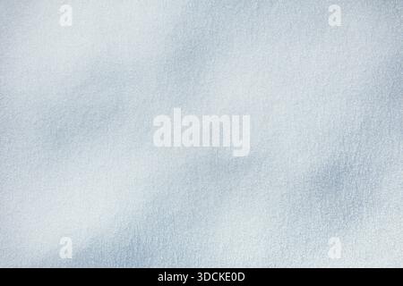 Snow texture. Brilliant, sparkling snow surface with delicate ice crystals and soft blue shadows. Sunlight catches the textured fresh snow, creating a Stock Photo