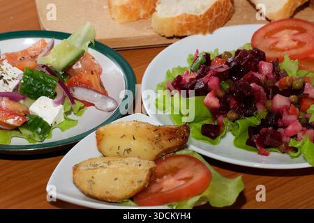 A colorful selection of salads and bread arranged beautifully on a table. Stock Photo
