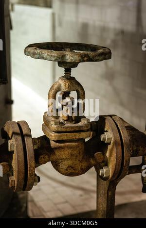 Abstract industrial pipeline fragment, Old rusted shut-off valve of a heating system Stock Photo