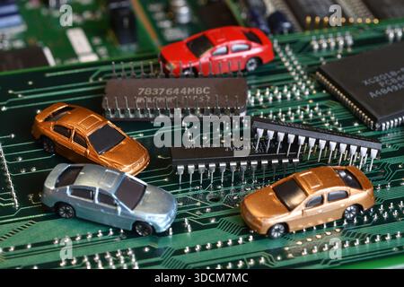 Toy cars on electronic board and microchip. The shortage of microchips and semiconductors creates a shortage of new cars. Conceptual image for semicon Stock Photo