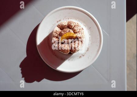 Banoffee pie dessert served on a plate in warm sunlight, highlighting creamy texture and caramel tones in a relaxed Mediterranean setting BirÅ¼ebbuÄa, Malta, 6 DEC 2025. Stock Photo
