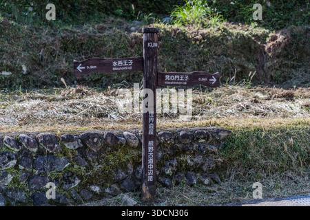A signpost on the Kumano Kodo between Hosshinmon-oji and Mizunomi-oji points toward Kumano Hongū Taisha Grand Shrine near Tanabe, Wakayama Prefecture, Japan. The post itself marks the trail as part of the Nakahechi route within the UNESCO World Heritage Kumano Kodo. Stock Photo