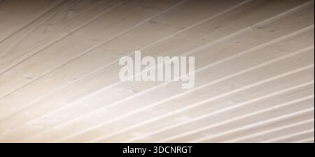 Close-up view of light-colored wooden planks of ceiling, showcasing smooth grain and subtle shadows. Ideal background for interior, home decor, produc Stock Photo