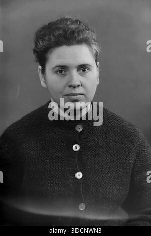 Slaviansk, Donetsk region, Ukraine, USSR. 1970s. A classic black and white studio portrait of Valentina Timofeevna Kravelis. The woman poses in a textured dark knitted cardigan with large pearlescent buttons, representing the authentic everyday fashion of the Soviet era. This close-up archival image captures the calm expression and dignity of a resident of the peaceful Donbas during the mid-Soviet period, preserving the visual heritage of the 20th century. Stock Photo