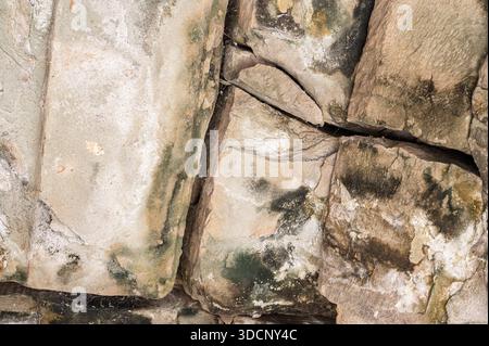Abstract grunge background theme featuring rough surface of historic grey sandstone masonry with erosion marks at famous asian landmark on sunny summe Stock Photo
