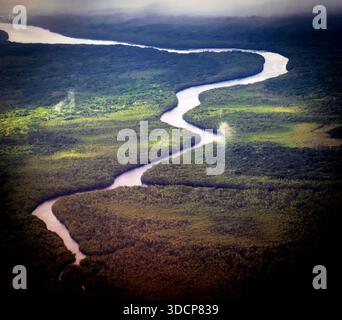 Aerial view of a winding river flowing through lush green agricultural ...