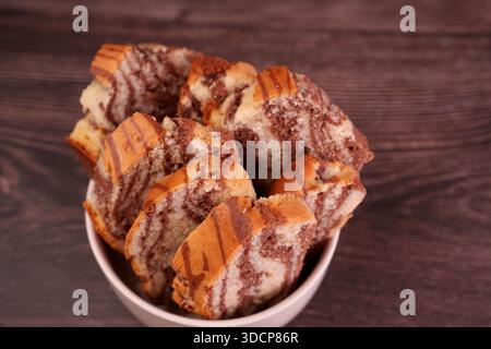 close-up of deliciously swirled marble pound cake slices in a bowl on wooden surface with warm brown and cream hues creating an inviting and homely at Stock Photo