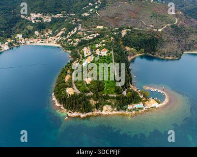 Stunning aerial panorama of the Kouloura and Kalami coastline in Corfu, Greece, showing the curved harbor, pebbled beaches, and dense cypress vegetati Stock Photo
