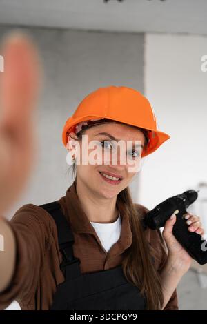 Woman Builder. Female construction worker making selfie on mobile phone. Technology, repair, construction and building concept. copy space Stock Photo