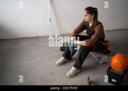 sad woman tired of construction finishing work strength to continue working. repair, construction and building concept. Stock Photo
