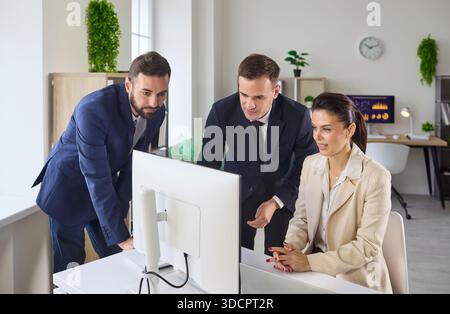 Executives reviewing data on desktop monitor in office, aligning goals strategy Stock Photo