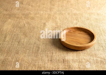 One wooden plate on jute cloth. Stock Photo