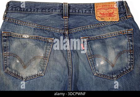 Italy, February 10, 2022. A close-up back view of a pair of classic blue Levi's 501 jeans, showing the leather patch, red tab, and distressed denim te Stock Photo