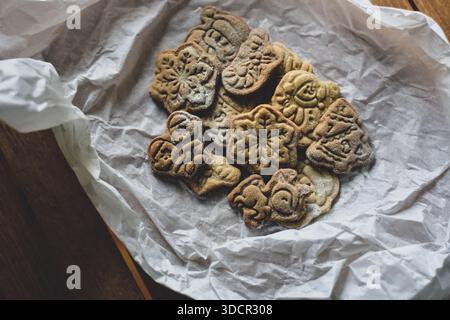 Gingerbread cookies in festive shapes on baking paper moody Stock Photo