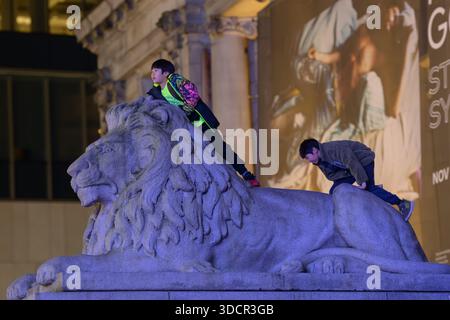 Children playing on stone lion Stock Photo