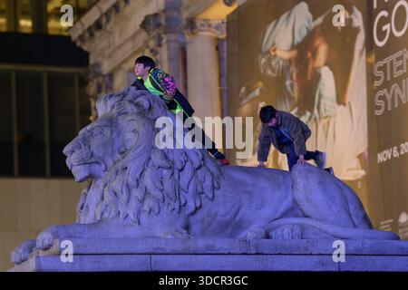 Children playing on stone lion Stock Photo