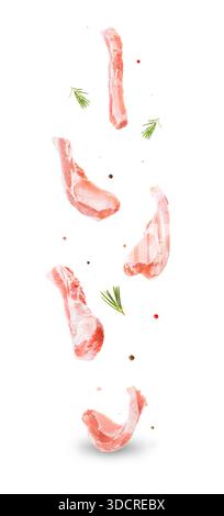 Fresh raw pork meat slices floating in air with rosemary and peppercorns isolated on white background. High quality photo Stock Photo