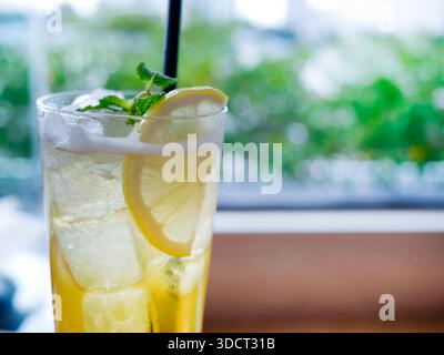 A cold yellow green beverage served in tall glass. Resembles an iced honey lemon green tea, virgin mojito, or citrus soda, is packed with crystal clea Stock Photo