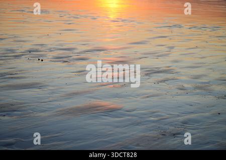 Sunset on the Atlantic coast. Reflections in the water in pastel tones. Stock Photo