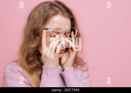 Side view portrait of woman pressing eyes in glasses showing dry eye irritation and headache from screen fatigue Stock Photo