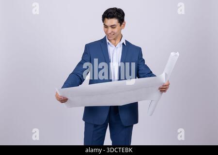 Architect in blue suit looking at rolled blueprint Stock Photo