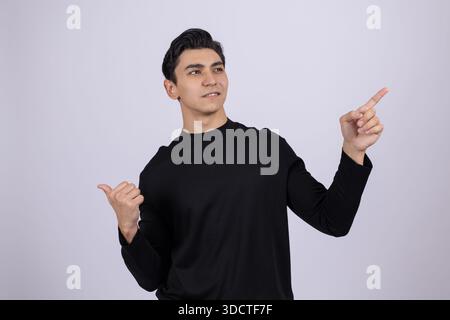 Man in black shirt pointing to the side space Stock Photo