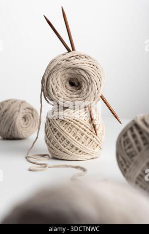 Neutral yarn balls with wooden needles and a wicker basket. Natural craft still life for knitting, handmade projects and cozy slow living themes. Soft Stock Photo