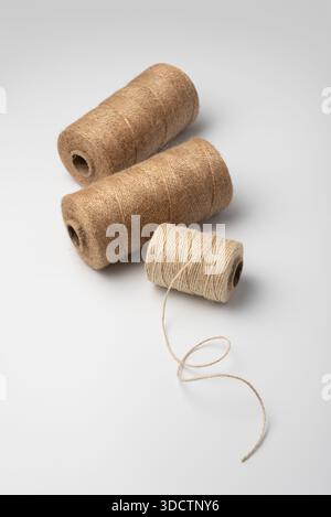 Two spools of natural jute twine on a white background. Rustic eco craft material for packaging, decor and DIY projects. Minimal clean studio shot. Stock Photo