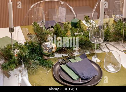 Table set up with festive Christmas ornaments in modern dining room interior Stock Photo