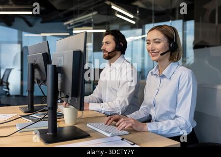 Professional call center agents in headsets collaborating at computers in a modern office, delivering friendly customer support, teamwork and efficient communication for clients Stock Photo