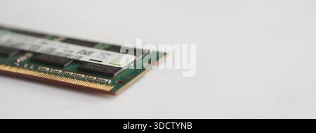A perspective shot of a laptop memory module highlighting the gold connector pins and the green recycle symbol on the label. Stock Photo