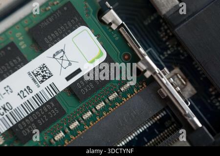 Macro shot of the metal clips securing a RAM module in the laptop motherboard slot. Demonstrates the locking mechanism for computer memory. Stock Photo