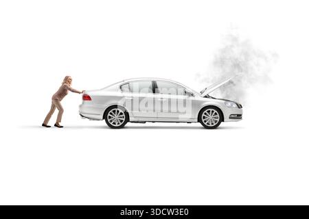 Woman pushing a broken down car with steam coming from the hood isolated on white background Stock Photo