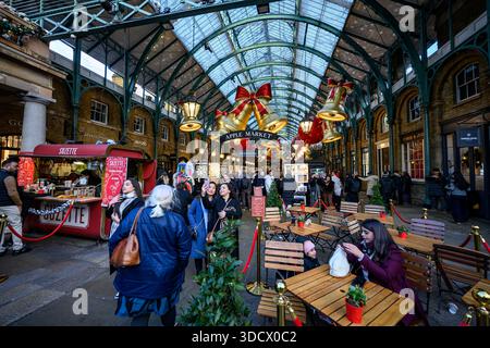 Festive scene at Covent Garden in London on 24 December 2025, featuring crowds of people walking and enjoying the Christmas market. Stock Photo