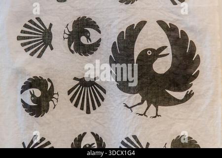 A fabric banner shows the three-legged crow Yatagarasu alongside the scallop shell, the emblems of two sister pilgrimage routes: the Kumano Kodo in Japan and the Camino de Santiago in Europe. In the Kumano region, the crow is regarded as a divine messenger and guide for pilgrims; its three legs represent heaven, earth and humankind. The two routes have been officially twinned since 1998; those who complete both in full receive the "Dual Pilgrim" stamp. Tanabe, Wakayama Prefecture, Japan. Stock Photo