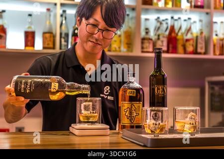 Staff at the Umeshu Bar in Tanabe prepare glasses for a tasting. The bar offers 140 plum liqueurs from 30 different producers in Wakayama. Man pouring Hamada Craft Liqueur brand Japanese plum liqueur Umeshu (梅酒) into a glass in Tanabe, Wakayama Prefecture, Japan Stock Photo