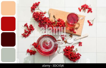 Glass cup and teapot of hot viburnum tea on white tile background. Different color patterns Stock Photo