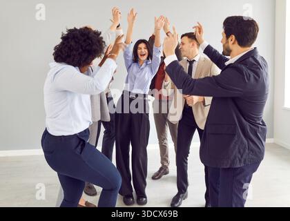 Young funny happy business people and company employees in suits having fun celebrating success Stock Photo