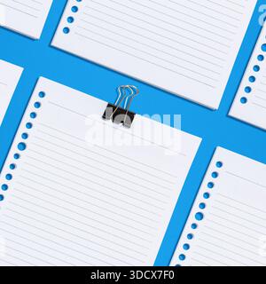 Flat lay composition featuring several lined paper sheets with hole punches, one held together with a black binder clip, against a bright blue backgro Stock Photo