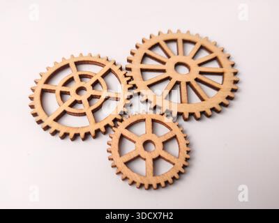 Closeup are wooden gear cutouts on a white background. Stock Photo